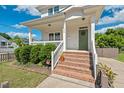 Inviting front entrance with brick steps, a covered porch, and a neatly landscaped yard at 309 S Haywood St St, Raleigh, NC 27601