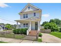 Charming two-story home with a inviting front porch and a beautifully landscaped yard on a sunny day at 309 S Haywood St St, Raleigh, NC 27601