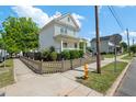 Street view of a two story home with white siding, a covered porch, and a cute picket fence at 309 S Haywood St St, Raleigh, NC 27601