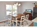 Well-lit dining room with a wooden table, six chairs, a chandelier, and a large window with a view at 312 Crusaders Dr, Morrisville, NC 27560