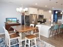 Stylish kitchen featuring white cabinets, granite countertops, stainless steel appliances, and an island with seating at 312 Crusaders Dr, Morrisville, NC 27560