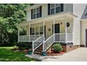 Inviting front porch with classic design elements and meticulously landscaped flower beds at 353 Spearhead Pl, Clayton, NC 27520