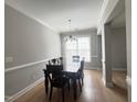 Formal dining room featuring an elegant chandelier, large window, and hardwood floors at 3927 Wedonia Dr, Cary, NC 27519