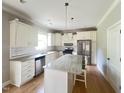Bright kitchen with a center island, stainless steel appliances, and white cabinets at 3927 Wedonia Dr, Cary, NC 27519