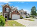 View of townhomes with well-maintained lawns and driveways on a sunny day at 401 Dyersville Dr, Morrisville, NC 27560