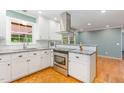 Modern kitchen featuring stainless steel appliances, granite countertops, and white cabinets at 4030 King Charles Rd, Durham, NC 27707