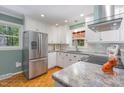 Well-lit kitchen with stainless steel refrigerator and views of the wooded exterior at 4030 King Charles Rd, Durham, NC 27707
