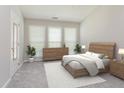 Bright bedroom featuring a wooden bed frame, dresser, and a sitting area with large windows for natural light at 503 Kinship Ln, Apex, NC 27502