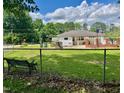Spacious backyard featuring a bench, chain-link fence, and mature trees at 508 E Mcneill St, Lillington, NC 27546