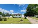 View of the rear of the property with a well-kept lawn and mature landscaping at 508 E Mcneill St, Lillington, NC 27546