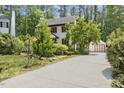 Two-story home with a long driveway leading to a detached garage and lush landscaping at 5704 Cholderton Ct, Raleigh, NC 27604