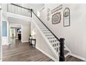 Open entryway showcasing hardwood floors, elegant staircase, and view to the living room at 60 Morning Mist Dr, Garner, NC 27529