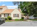 View of a light-yellow townhome with a brown roof and dedicated parking at 6540 English Oaks Dr, Raleigh, NC 27615