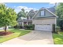Lovely two-story home boasting a well-kept lawn, mature trees, and an attached two-car garage at 68 Tanners Way, Clayton, NC 27527