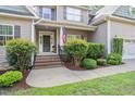 Inviting front porch with brick steps, lush greenery, and classic architectural details, showcasing curb appeal at 68 Tanners Way, Clayton, NC 27527