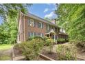 Charming two-story brick home with blue shutters surrounded by lush greenery at 7801 Wood Way Ct, Raleigh, NC 27606