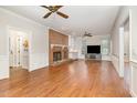Spacious living room with hardwood floors, brick fireplace, and ceiling fans at 7801 Wood Way Ct, Raleigh, NC 27606
