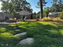 Lush backyard with a stone patio, fire pit, and a privacy fence, creating an inviting outdoor space at 809 Trinity Park Dr, Wake Forest, NC 27587