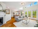 Bright living room with fireplace, herringbone floors, and access to the outdoor deck at 9 Lake Village Dr, Durham, NC 27713