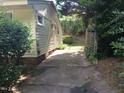 Property showing driveway access alongside house with green shrubs and mature trees at 912 Dixie Trl, Raleigh, NC 27607