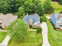 Aerial view of a well-maintained home with a long driveway and a lush, green lawn at 921 Riverwood Dr, Clayton, NC 27527