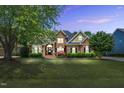 Charming two-story brick home with manicured lawn, mature trees, and classic curb appeal at 921 Riverwood Dr, Clayton, NC 27527