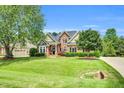 Charming two-story brick home with manicured lawn, mature trees, and classic curb appeal at 921 Riverwood Dr, Clayton, NC 27527
