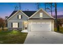 Charming home featuring a two-car garage, stone accents, and a well-maintained lawn at 100 Carol Cir # 17, Louisburg, NC 27549