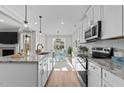 Modern kitchen features white cabinets, granite counters, stainless appliances, and an eat-in island at 100 Carol Cir # 17, Louisburg, NC 27549