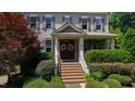 Close-up of the front porch with brick steps, decorative wreaths, and a well-manicured garden at 101 Eden Glen Dr, Holly Springs, NC 27540