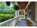 Inviting front porch with ferns hanging from the ceiling and a wooden bench, offering a relaxing outdoor space at 101 Eden Glen Dr, Holly Springs, NC 27540