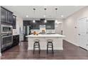 Modern kitchen with a large island, stainless steel appliances, dark cabinetry, and seating for casual dining at 1049 Lakebrink Dr, Morrisville, NC 27560