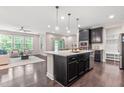 Open-concept kitchen featuring a large island with pendant lighting, stainless steel appliances, and living area access at 1049 Lakebrink Dr, Morrisville, NC 27560