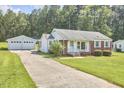 Ranch home and detached garage with a long driveway at 1105 Horseshoe Rd, Durham, NC 27703