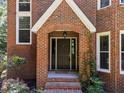 Inviting front entrance featuring a brick archway and classic door at 11425 Horsemans Trl, Raleigh, NC 27613