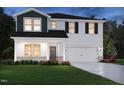 Two-story home with a blue gable, white siding, a two-car garage, and a well-manicured lawn at 1143 Winding Spring Dr, Mebane, NC 27302