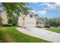 Side view of a two-story yellow home featuring a driveway and well-maintained lawn at 1208 Dunn Creek Xing, Wake Forest, NC 27587