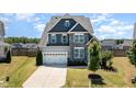 Two-story home features stone accents, well-kept lawn, and attached two-car garage in a suburban setting at 123 Gunderson Ln, Garner, NC 27529
