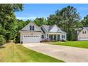 Inviting home featuring a two-car garage, manicured lawn, and charming front porch at 123 Holiday Island Dr, Garner, NC 27529