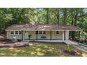Charming single-story home with a cozy front porch and landscaped yard, nestled in a serene, wooded setting at 1302 Buffaloe Rd, Garner, NC 27529