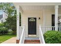 Inviting front porch with black front door and charming architectural details at 131 Cricketgrass Dr, Cary, NC 27513