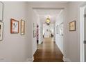 Elegant hallway with hardwood floors, decorative lighting, and framed artwork at 131 English Violet Ln, Raleigh, NC 27610
