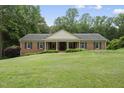Classic brick home with a well-maintained lawn and charming covered entrance at 1401 Granada Dr, Raleigh, NC 27612
