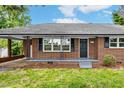 Close up of brick house with covered front porch and black front door at 1592 Boone Rd, Elon, NC 27244