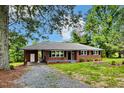 Inviting brick home with a spacious front yard, featuring a covered entrance and classic design elements at 1592 Boone Rd, Elon, NC 27244