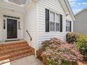 Close-up of the front entrance showing brick steps, black door, and mature landscaping at 1662 Beechaven Rd, Fuquay Varina, NC 27526
