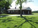 Brick ranch-style home on a large lot with mature trees and a paved driveway at 1700 Warrenton Rd, Henderson, NC 27537
