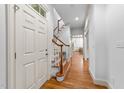 Bright foyer with hardwood floors, a staircase, and a glimpse into the home's elegant interior at 1711 Happiness Hill Ln, Raleigh, NC 27614