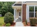 Inviting front porch with classic columns and brick accents, providing a warm welcome to the home at 233 Hammond Wood Place, Morrisville, NC 27560