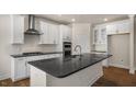 Stylish kitchen showcasing white cabinets, stainless steel appliances, dark countertops and a large island at 2332 Horton Park Dr, Apex, NC 27539